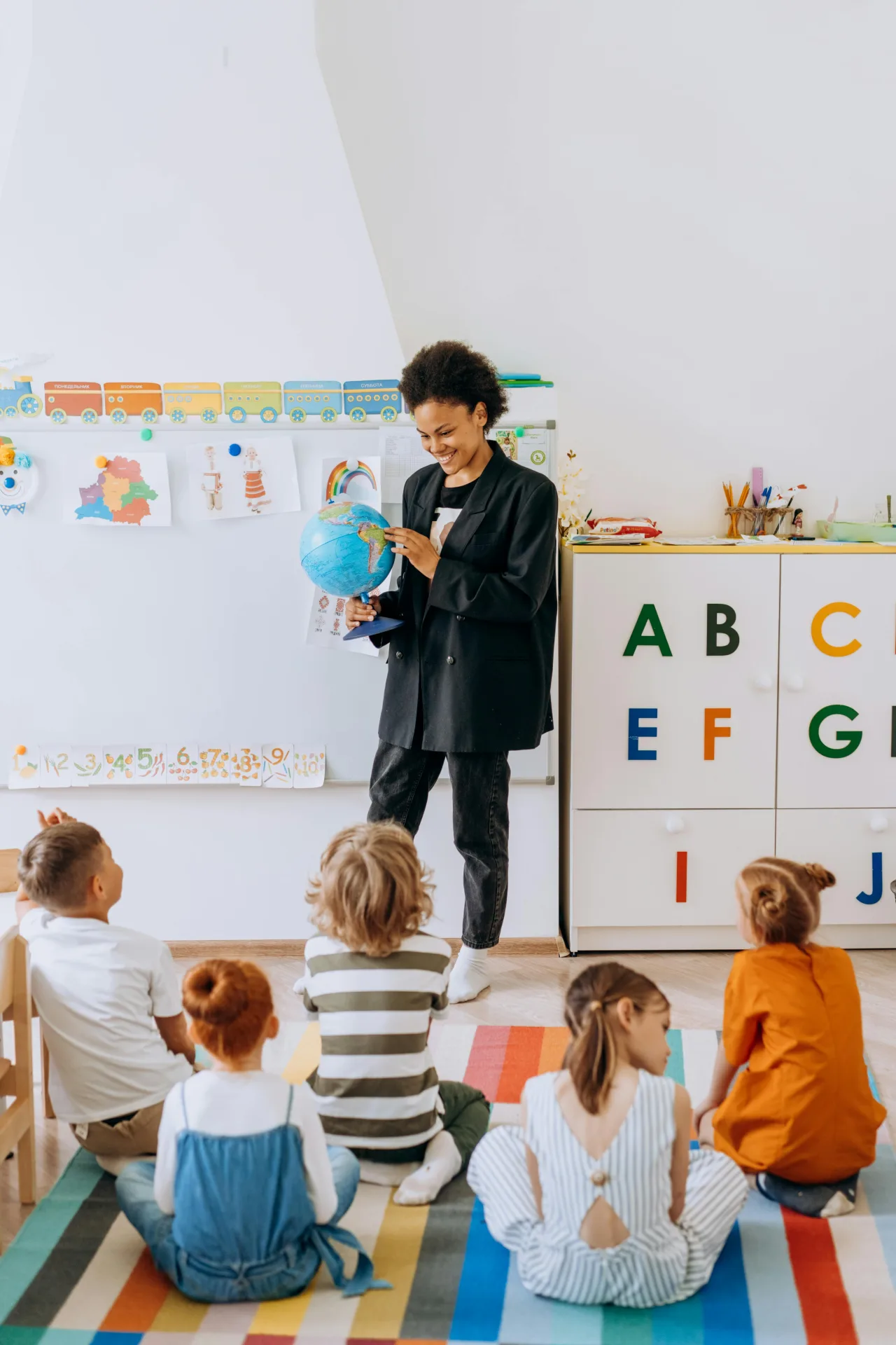 Maestra mostrando globo terráqueo — educación inclusiva y especial