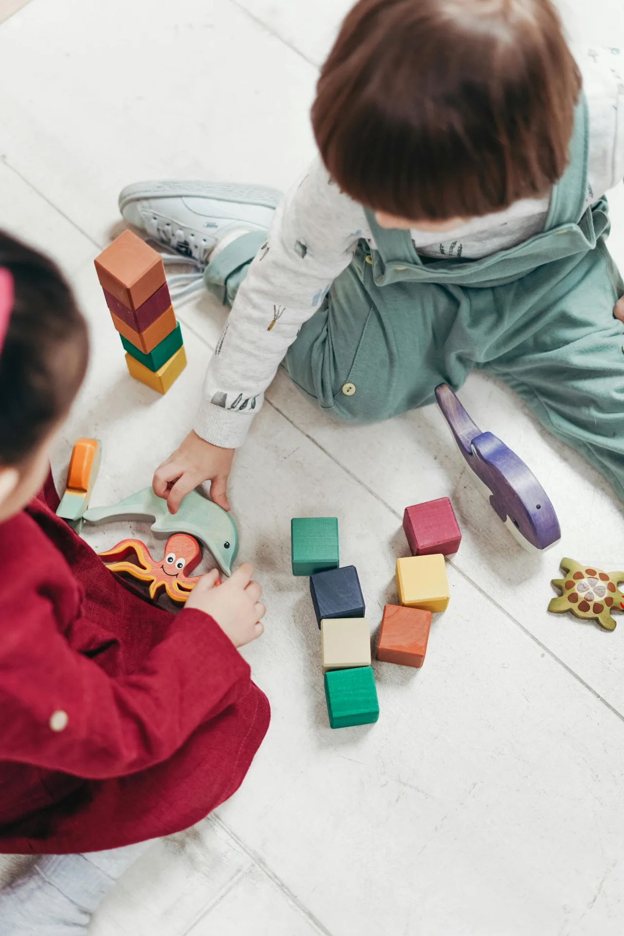 Niños jugando con bloques de madera — hitos del desarrollo infantil